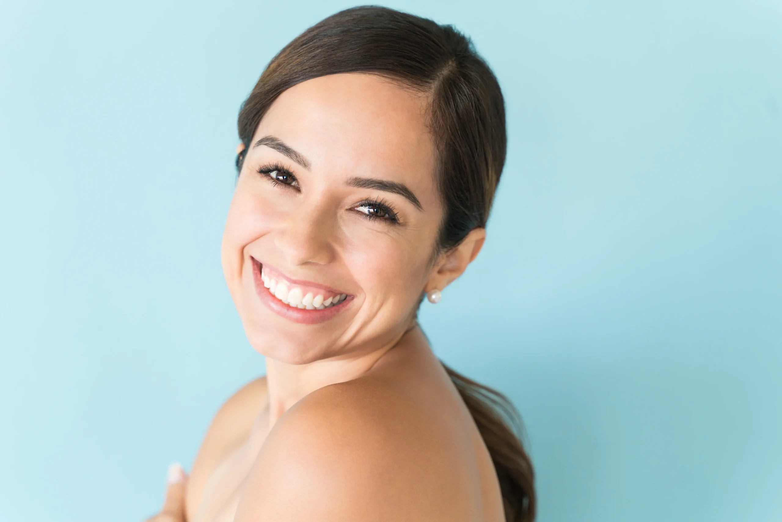 Beautiful woman with a radiant, perfect Hollywood smile in Abu Dhabi, showcasing the exceptional results of cosmetic dentistry and smile makeover services.